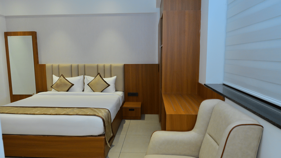 Bedroom of Bhavanis Vista By Icon featuring a bed, a headboard, a mirror, and a window.