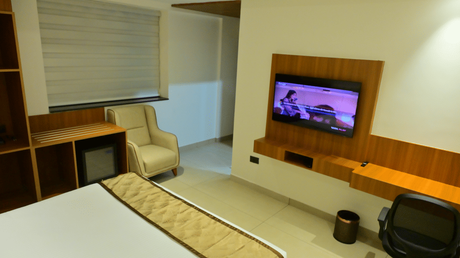 Bedroom of Bhavanis Vista By Icon featuring a bed, a headboard, a television, and a desk.