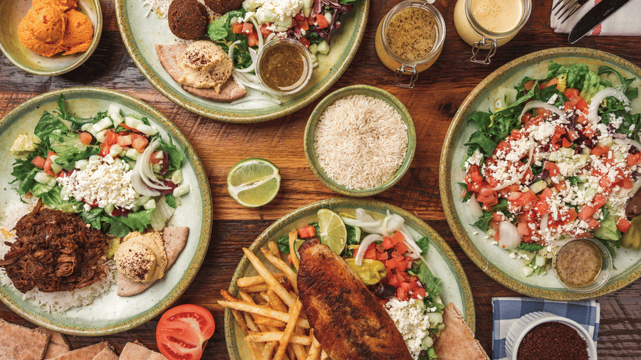 Overhead view of a table spread featuring multiple plated dishes and fries.