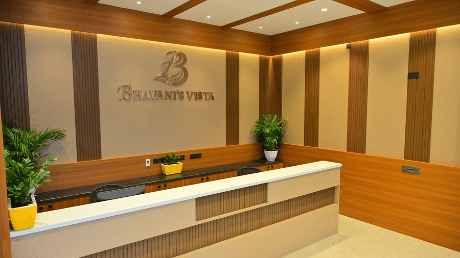 Reception desk of Bhavanis Vista By Icon featuring a counter, signage, and potted plants.