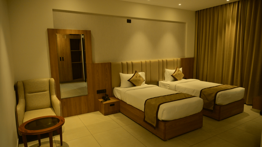 Bedroom of Bhavanis Vista By Icon featuring twin beds, a headboard, and an armchair.