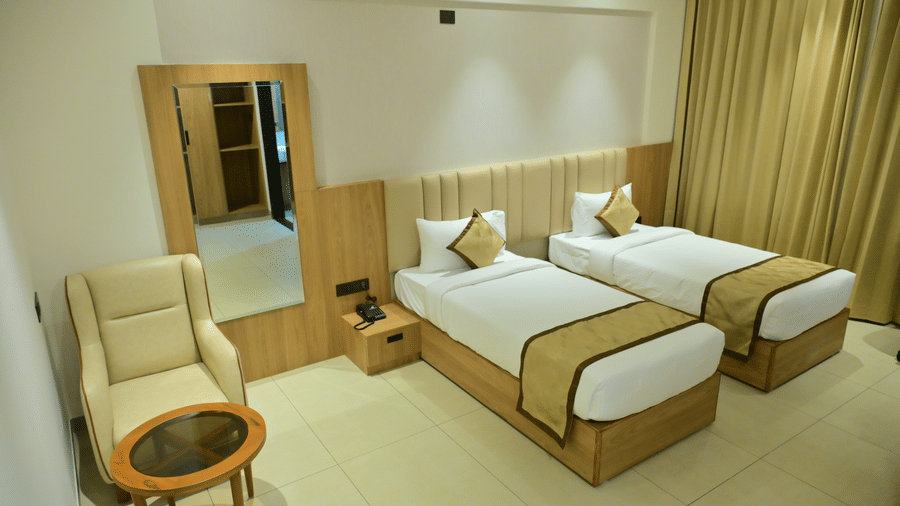 Bedroom of Bhavanis Vista By Icon featuring twin beds, a headboard, an armchair, and a round table.