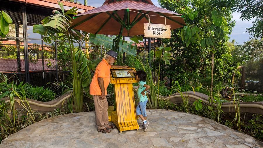 a small child using the interactive kiosk with another elderly person next to her