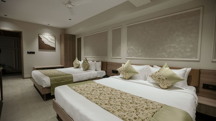 A comfortable hotel room with two large beds, featuring decorative pillows and bedding - Biznotel By Pride Surat