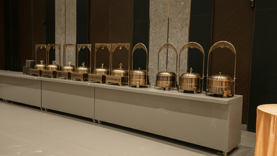 Elegant buffet setup at Biznotel by Pride Surat featuring traditional metallic chaffing dishes.