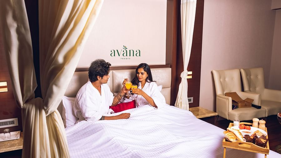 A couple relaxing in bed in a romantically decorated room.
