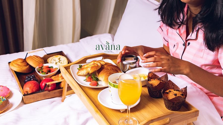 Close-up of woman having a wholesome breakfast served on a wooden tray in bed.