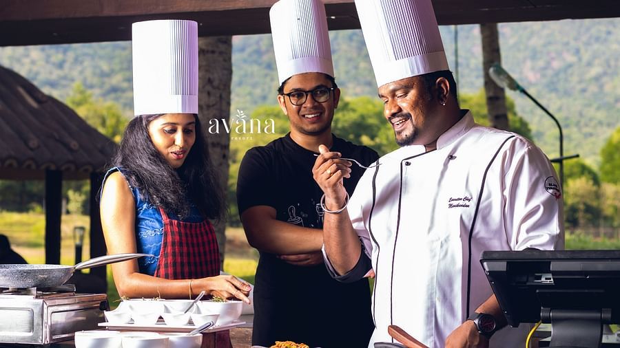 Chefs posing together in an open kitchen setup with mountains in the background. 