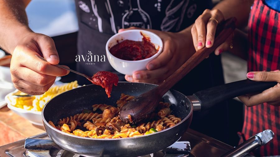 Chef preparing a vibrant dish in a pan, pouring sauce while cooking.
