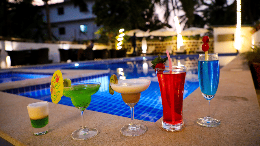 5 glasses of drinks placed on the side of a pool at Amara Grand Baga, Goa.