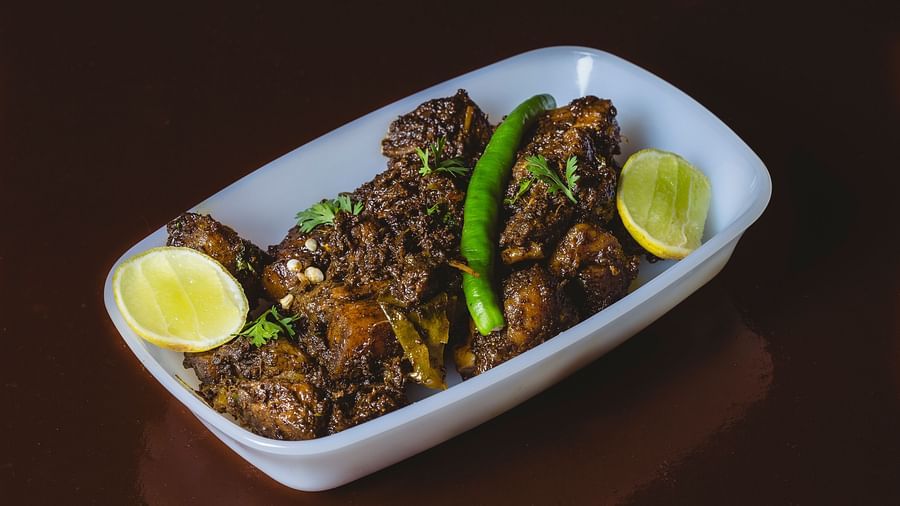 A chicken dish with lemon pieces on it at The canopy, Capitol Village Resort, Madikeri