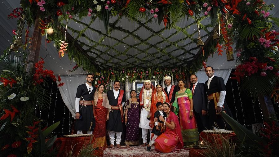 A traditional kodava wedding with people posing for a picture at Aiyanna Lawns, Capitol Village Resort, Madikeri