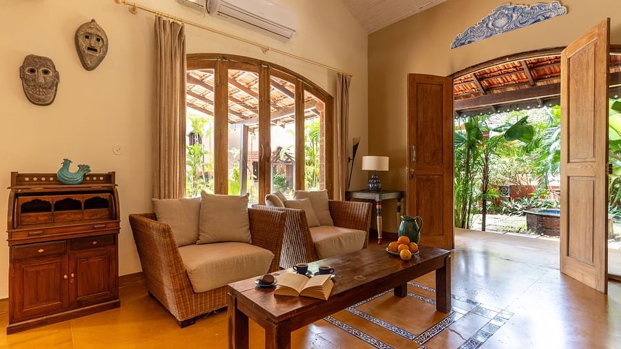 Image of living room displaying sitting area with couches and a coffee table and the walls featuring showpieces and large windows