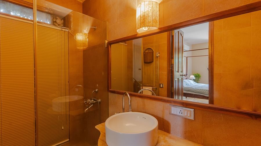 Image of a bathroom featuring a sink and a mirror along with a shower place next to it