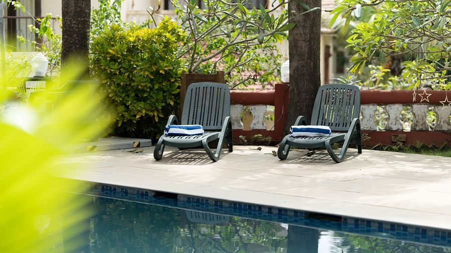 A couple of lounges placed next to the pool on the pool deck