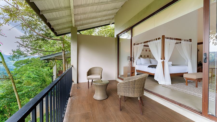 A side view of balcony with two chairs and a jute stool | Celestial Hills - Villas & Suites, Kandy