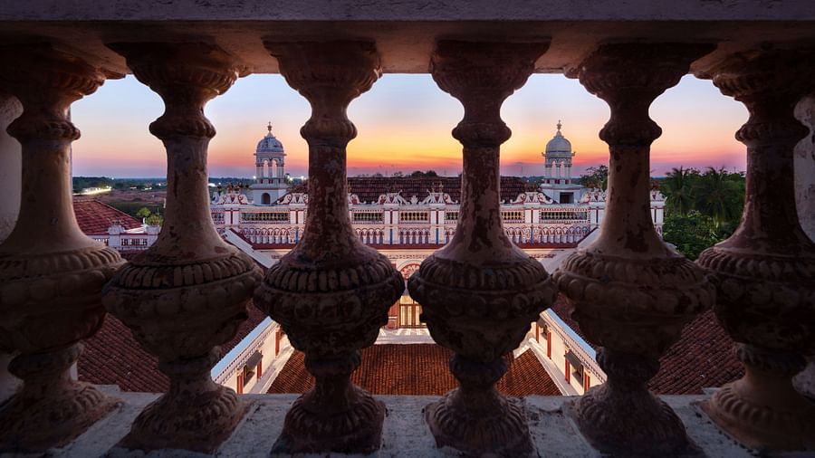 View from a balcony showcasing intricate balustrades overlooking the ornate architecture of Chidambara Vilas Resort at sunset