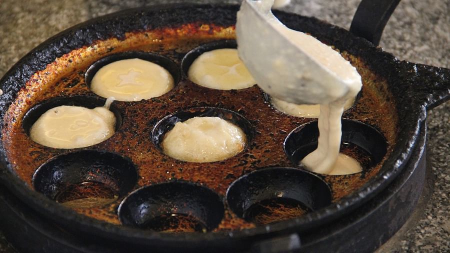 Appams being made in a cast iron pan
