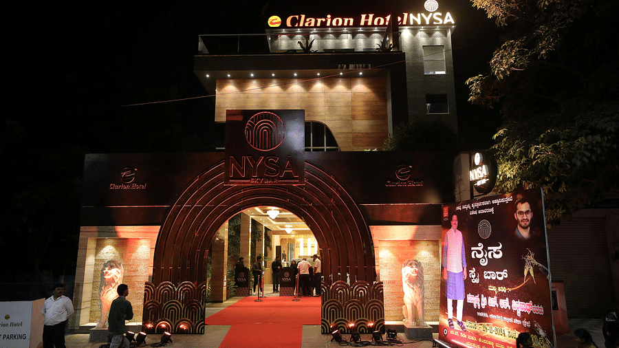 Night view of Clarion Bangalore, featuring a grand entrance with a red carpet, a decorative arch, and a promotional banner for an event.