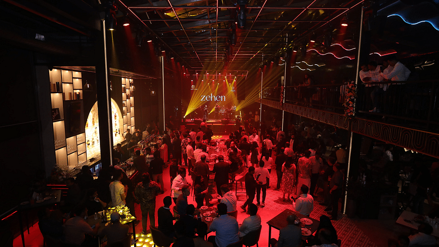 A top-angle view of the crowd dancing on the floor by the bar, illuminated by disco lights at Nysa Skybar, Bengaluru.