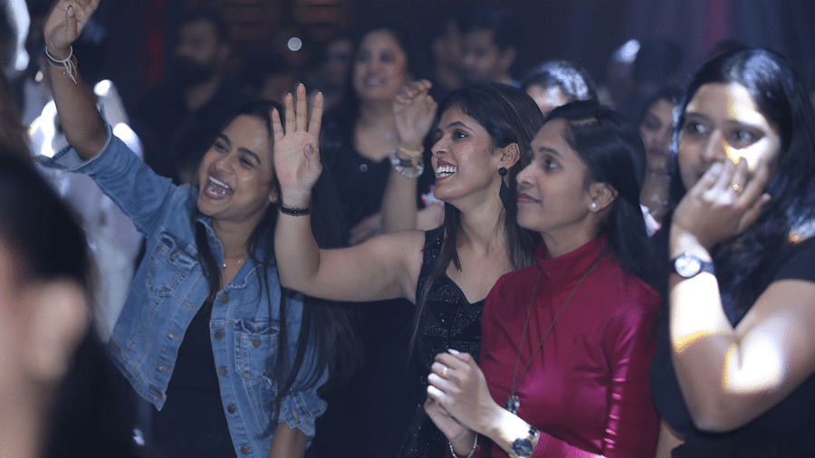 A group of people enjoying and cheering at a party at Nysa Skybar, Bengaluru.