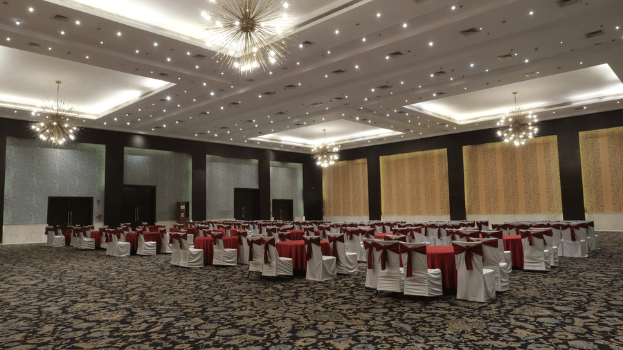 The spacious Clarks Brij Convention Centre featuring statement chandeliers, elegant seating arrangements, and a refined setting prepared for a large wedding celebration or reception | Clarks Amer, Jaipur