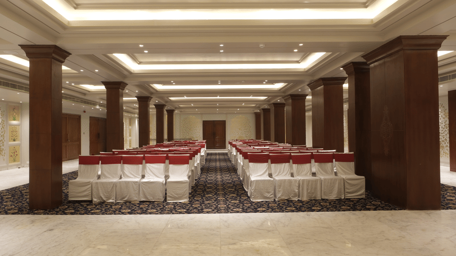The Swarn Mahal with theatre-style seating, wooden columns, ambient lighting, and spacious interiors prepared for wedding functions and social events | Clarks Amer, Jaipur