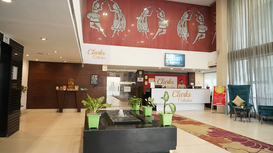 A reception area adorned with plants and a water fountain at Clarks Collection, Bhavnagar