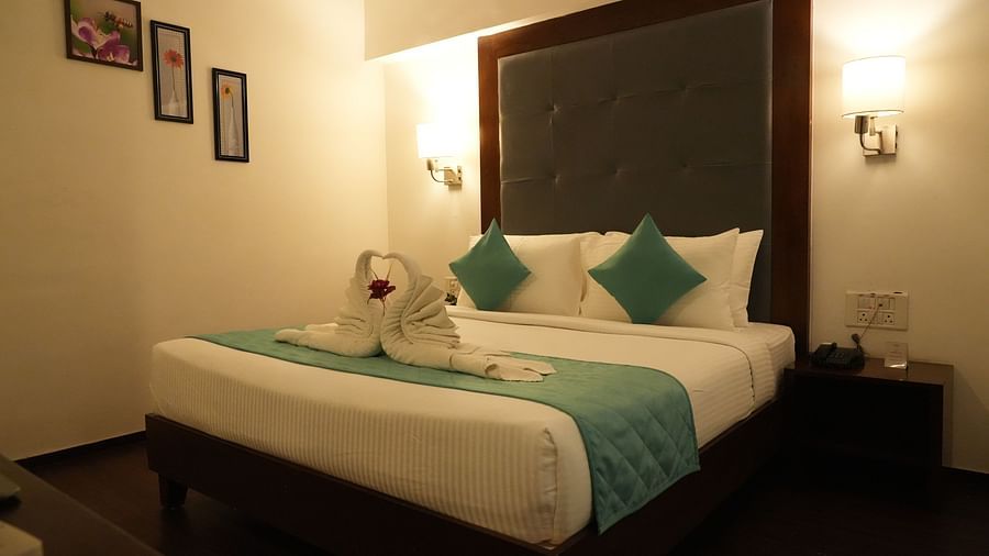 Side view of Suite room featuring a cosy bed with two lights on each side at Clarks Collection, Bhavnagar