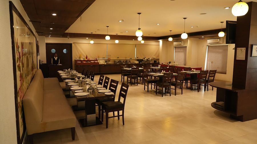 A restaurant with seating arrangements and ceiling lights at Clarks Collection, Bhavnagar