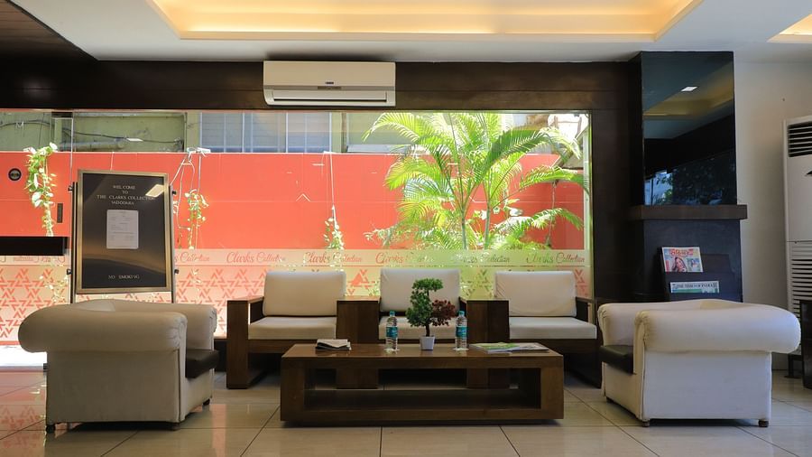 Lobby with Two four single sofa seats, a center table in the middle and a full length glass door and wall