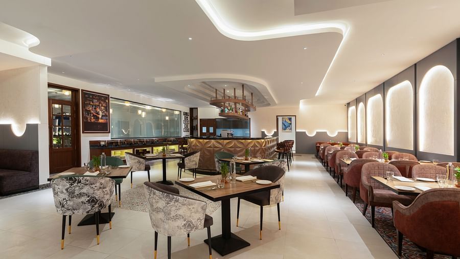 Modern dining area with sleek furniture and high ceilings.