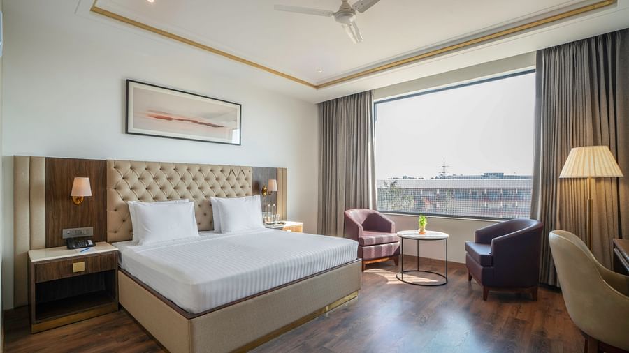 Modern hotel room with a minimalist design and natural light - Clarks Inn, Dehradun