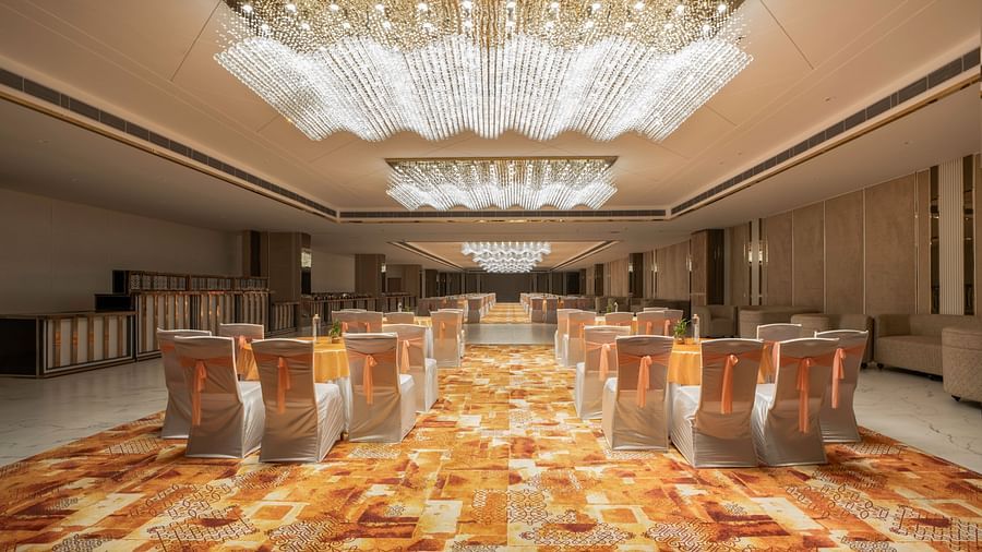 Grand banquet hall with elegant chandeliers and plush seating.