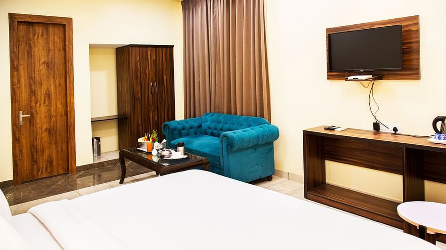 Spacious rooms with premium white linens and blue sofa