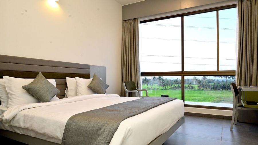 Well lit deluxe room with a double bed and large windows - Clarks Inn Express, KRS Road, Mysore