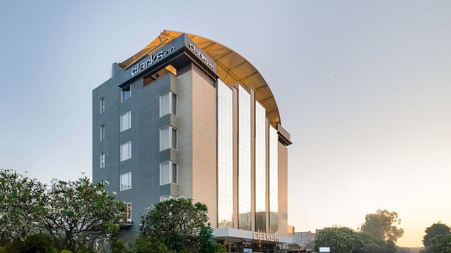 Exterior view of a Clarks Inn hotel, showcasing its modern architecture and surrounding landscape.