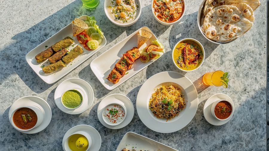 Overhead spread of Indian dishes including naan, curry bowls, rice and chutneys arranged on a stone tabletop at Clarks Inn Suites, Hyderabad