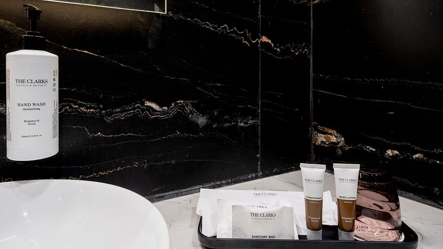  Close-up of bathroom toiletries on a black tray beside a white sink on marble countertop at Clarks Inn Suites, Hyderabad