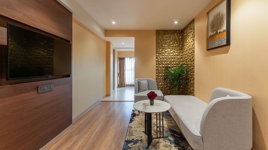  Cosy living area with white sofa, round coffee table, TV unit, and textured accent wall at Clarks Inn Suites, Hyderabad