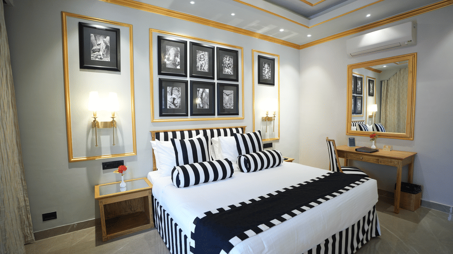 An Executive Suite bedroom at Clarks Khajuraho with a neatly made bed, patterned bedding, framed artwork above the headboard, and side lamps.
