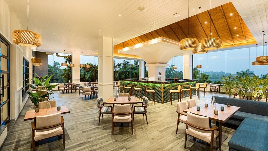 A diagonal view of the rooftop dining area showcases warm lighting and neatly arranged tables and chairs, creating a welcoming ambience for guests at Cloud9 Sarovar Premiere, Palolem Goa
