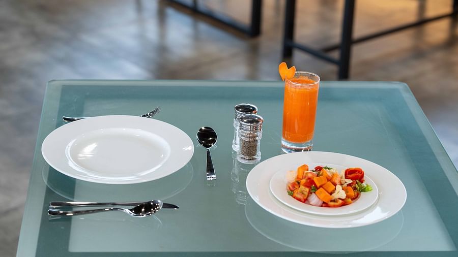 Fruits and orange juice placed on a glass table - Court 11, Kochi