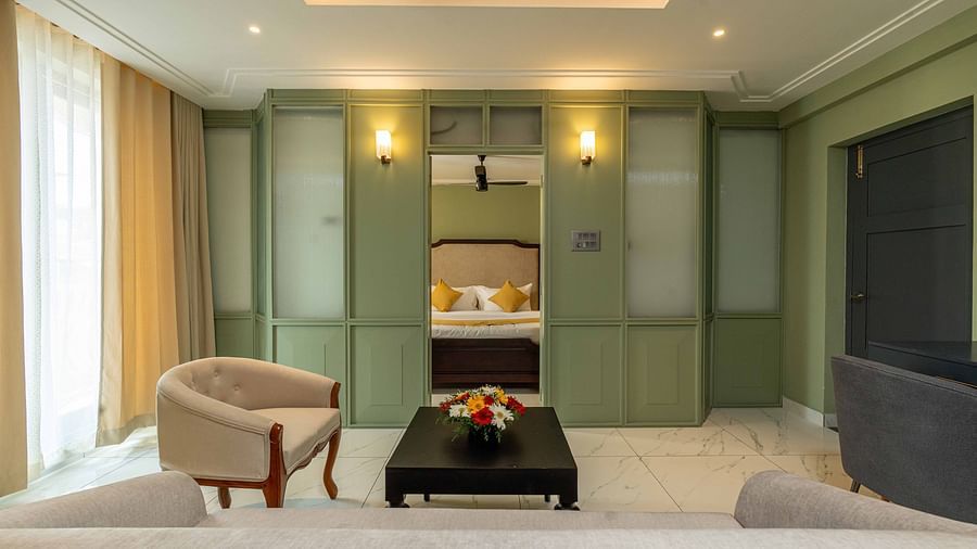 A living area with comfotable sofa and a chair in Suite room - Court 11, Kochi