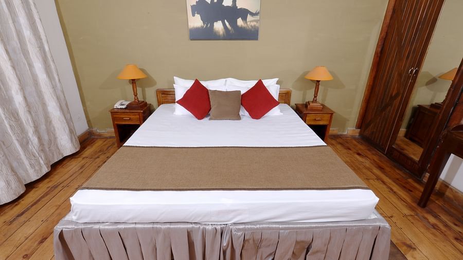 room with a king size bed and wooden flooring at destiny the farm resort