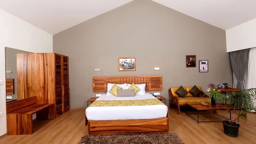 room with a king size bed and wooden interiors at destiny the farm resort