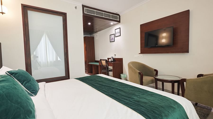 An image of the executive room with a large bed placed in front of a wall-mounted television - Deventure Sarovar Portico, Patel Nagar