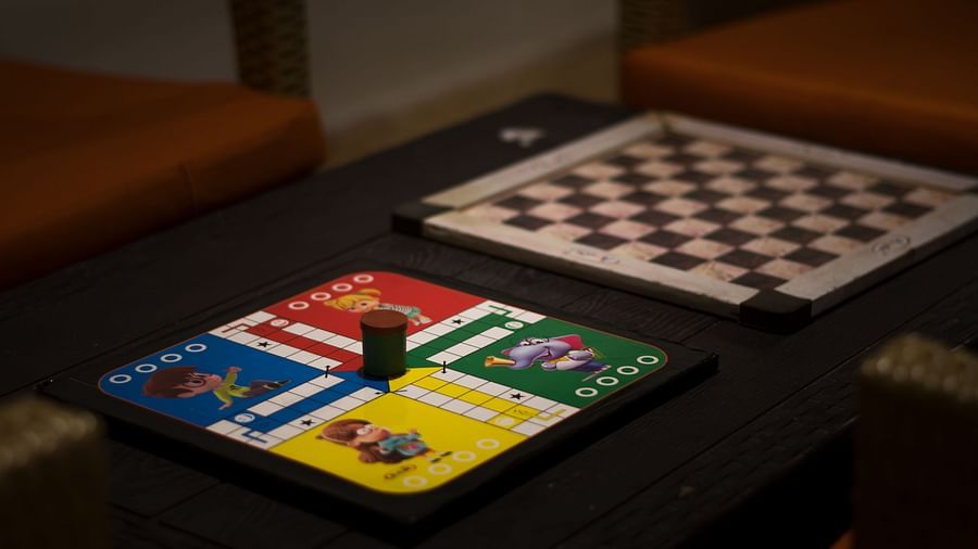  A close-up of classic board games, checkers and Ludo, set up on a table, offering entertainment for all ages during their stay - Digantaa Resort in Mukteshwar