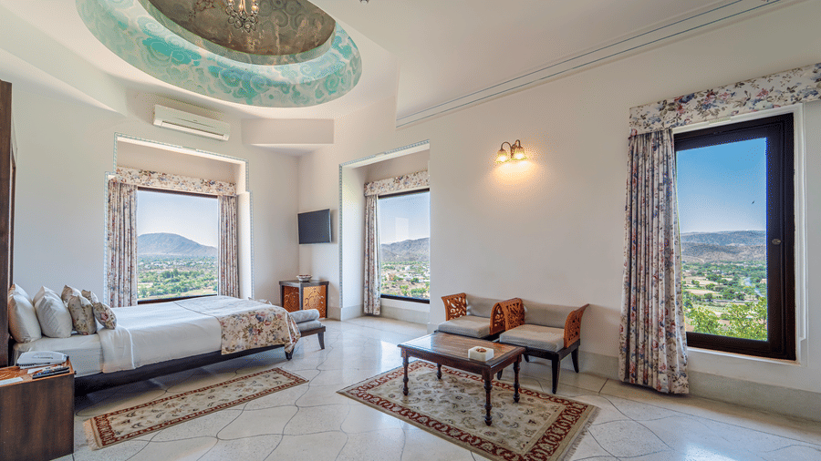 A regal suite showcasing a hand-painted domed ceiling, traditional rugs, and multiple viewing windows - Fateh Garh, Udaipur