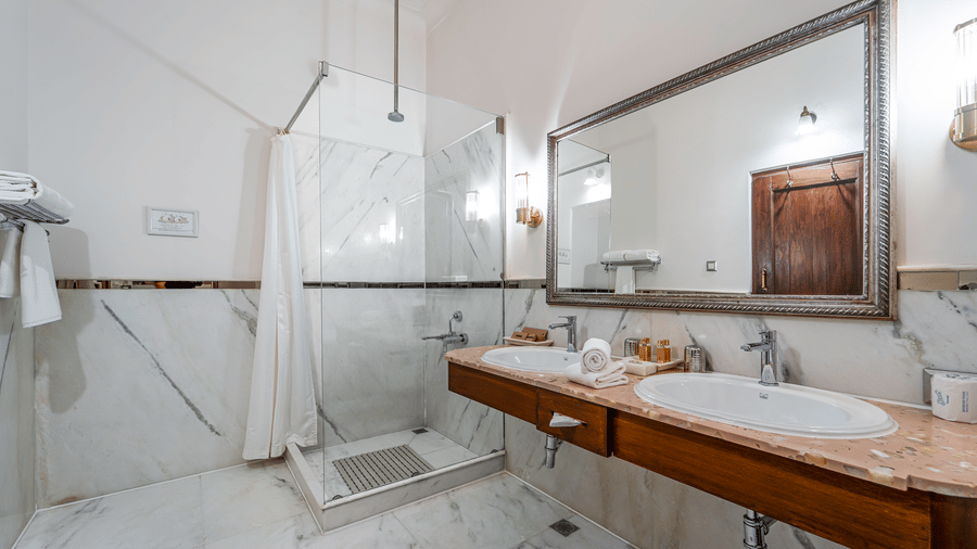 A luxury marble bathroom featuring a wide double vanity, large mirror, and high-end fixtures - Fateh Garh, Udaipur